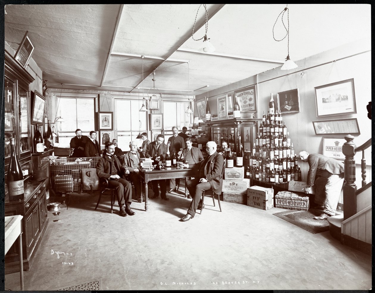 Gruppe von Männern, die Wein trinken bei G.L. Nicholas, Wein- und Spirituosenhändler, 43 Beaver Street, New York, 1895 von Byron Company