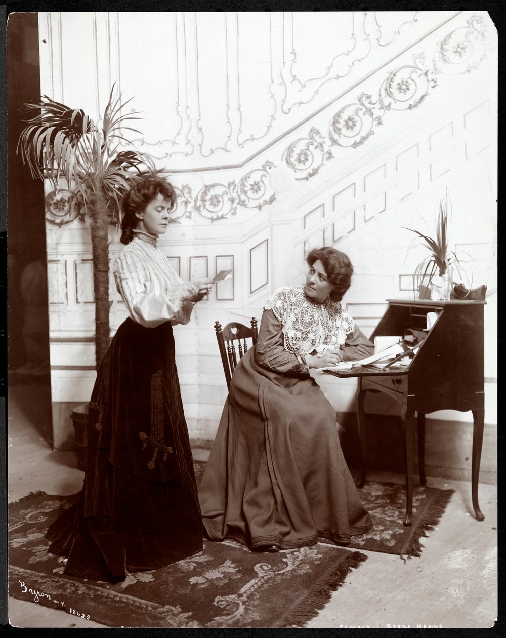 Zwei weibliche Bühnenarbeiterinnen auf einer Bühne, New York, 1904 von Byron Company