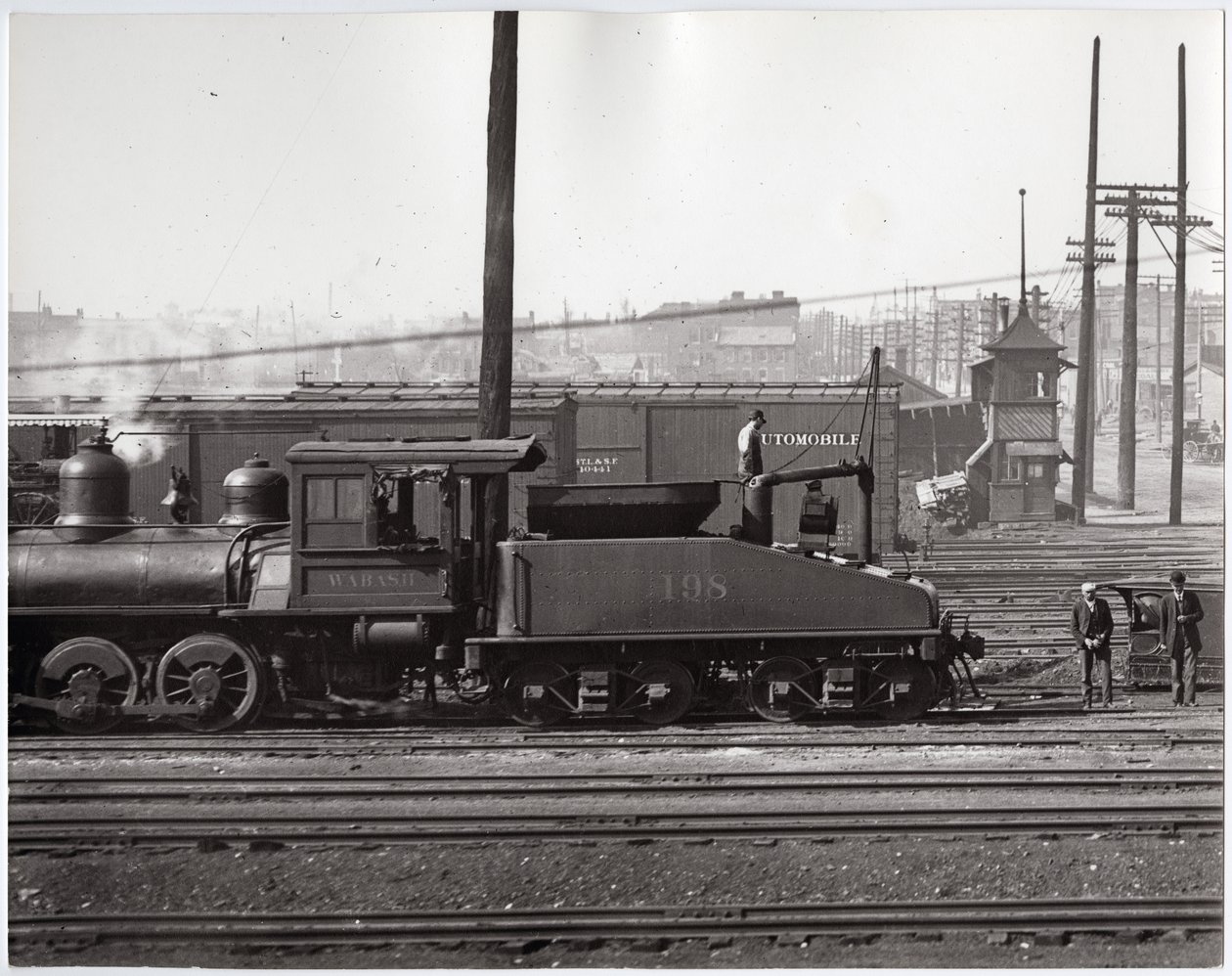 Dampflokomotive und Eisenbahnwagen in einem nicht identifizierten Bahnhofsbereich von Charles Clement Holt