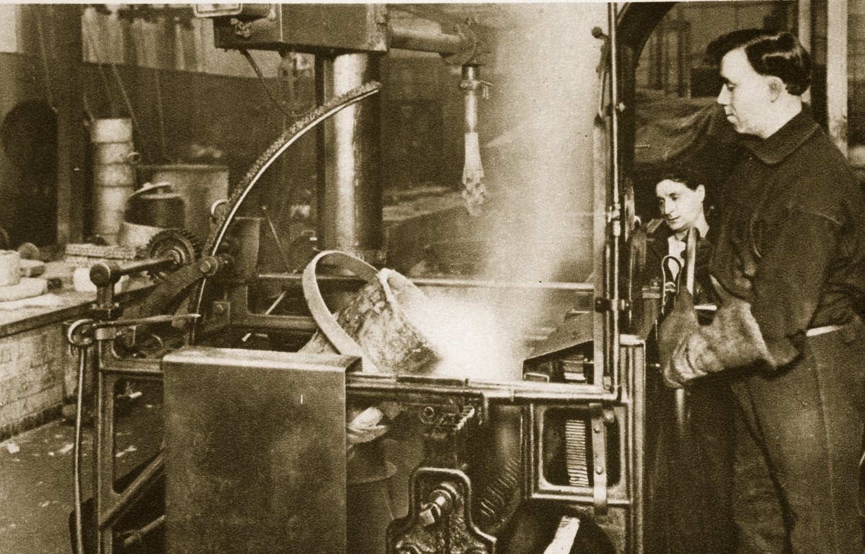 Geldherstellung: Ein Topf mit flüssigem Metall wird in eine Maschine gesenkt von English Photographer