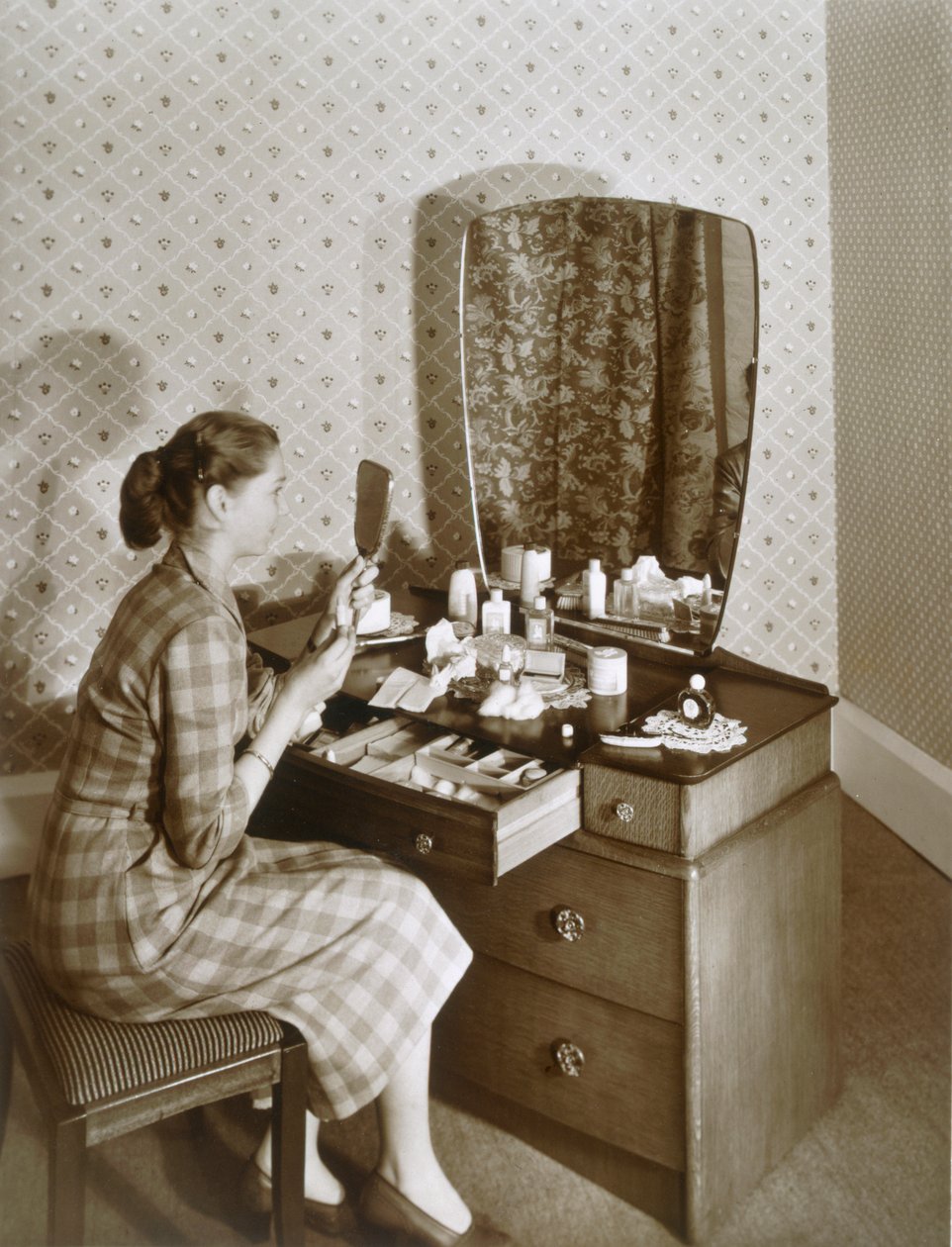 Frau an ihrem Frisiertisch, ca. 1955 (Sepia-Foto) von English Photographer