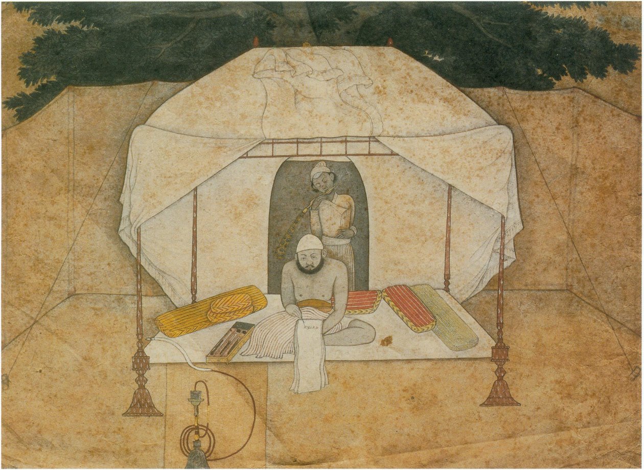 Balwant Singh sitzt schreibend auf einem Feldbett von Nainsukh
