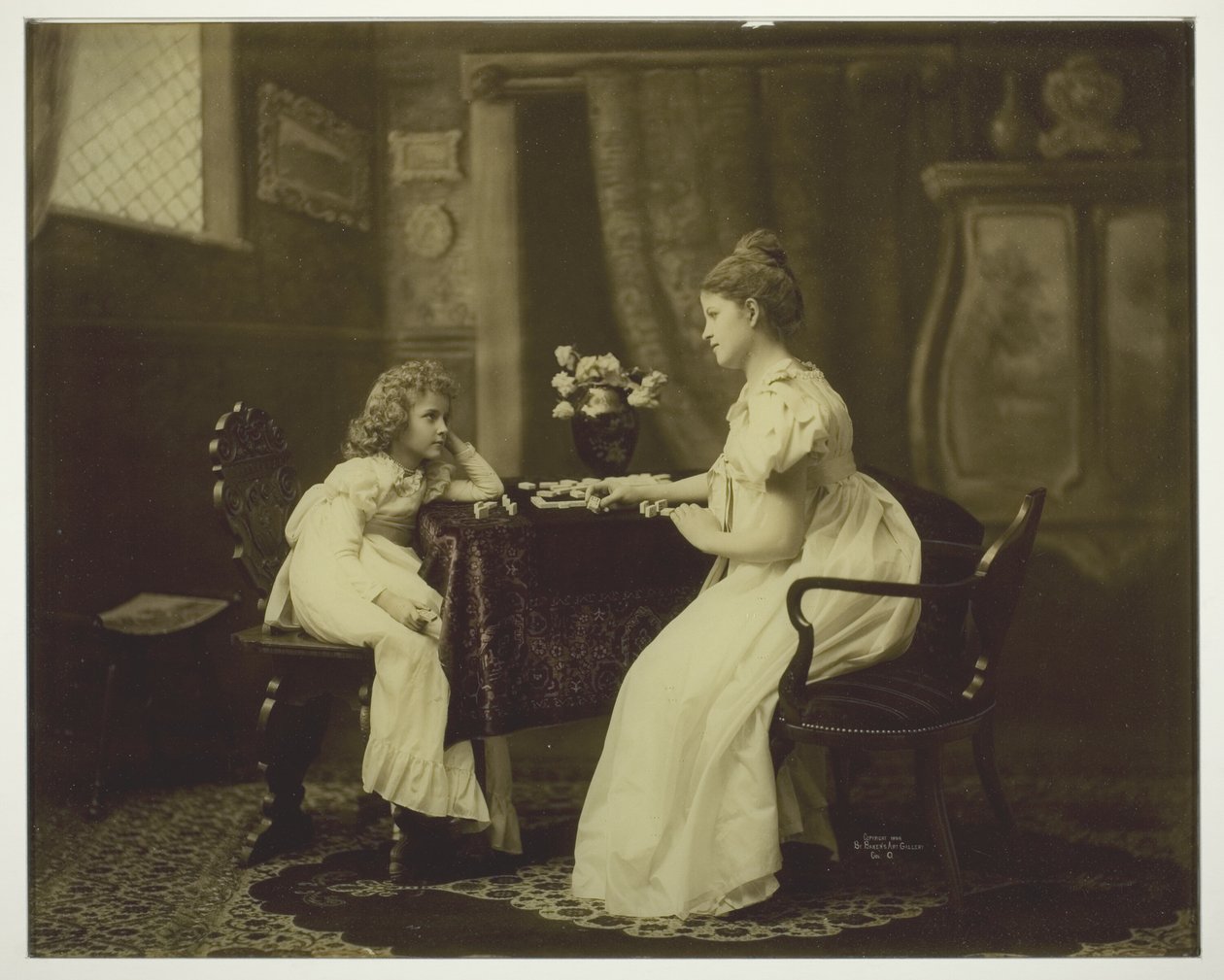 Frau und Kind spielen Domino am Tisch von Unknown