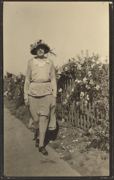 [Frau geht entlang eines Zauns mit Blumen] von Louis Fleckenstein