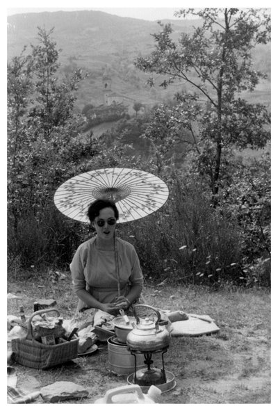 Frau unter einem Sonnenschirm beim Picknick, ca. 1950-1969 von Unbekannt