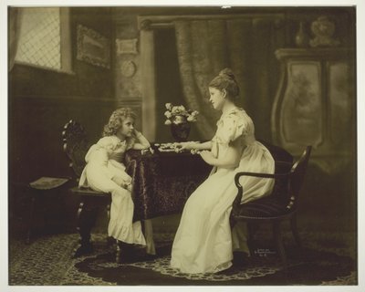 Frau und Kind spielen Domino am Tisch von Unknown