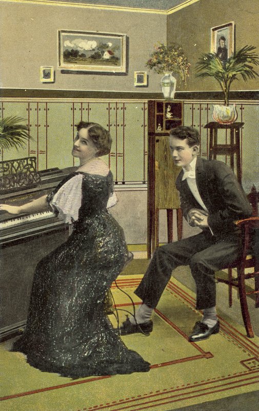 Junger Mann bewundert hübsches Mädchen, das Klavier spielt von American School